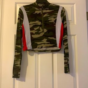 A camouflage crop top, with white and red stripes, with a zipper.